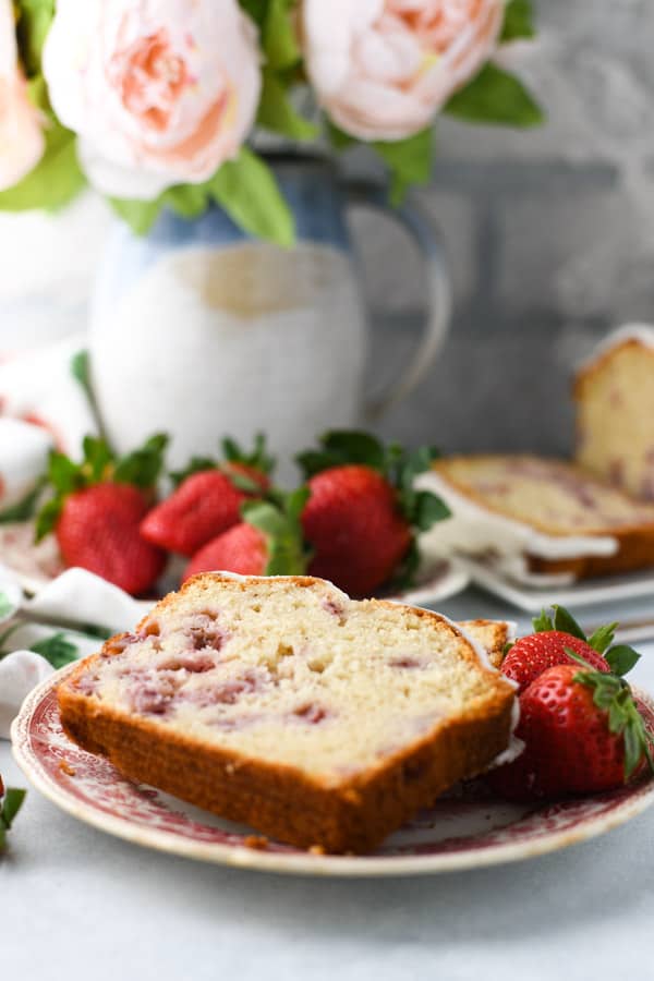 Slice of strawberry quick bread on a red and white plate