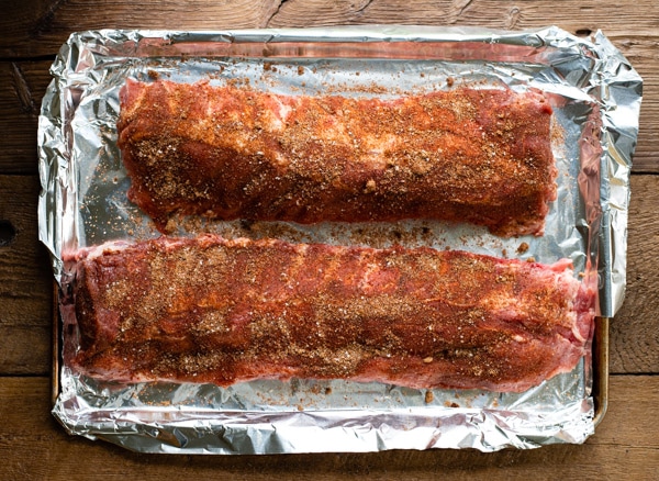 Process shot showing how to cook baby back ribs with dry rub in the oven