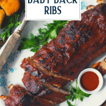 Overhead shot of a tray of pork baby back ribs with text title overlay
