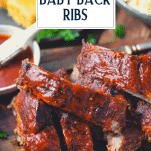 Close shot of oven baked baby back ribs on a cutting board with text title overlay
