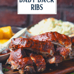 Baked baby back ribs on a cutting board with text title overlay