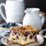 Side shot of a slice of blueberry buckle cake with cinnamon streusel topping