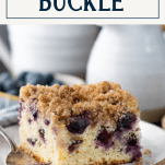 Close side shot of blueberry buckle recipe on a plate with text title box at top