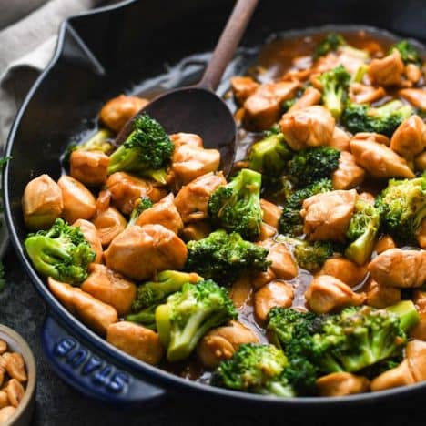 Close up square image of chicken and broccoli stir fry in a skillet