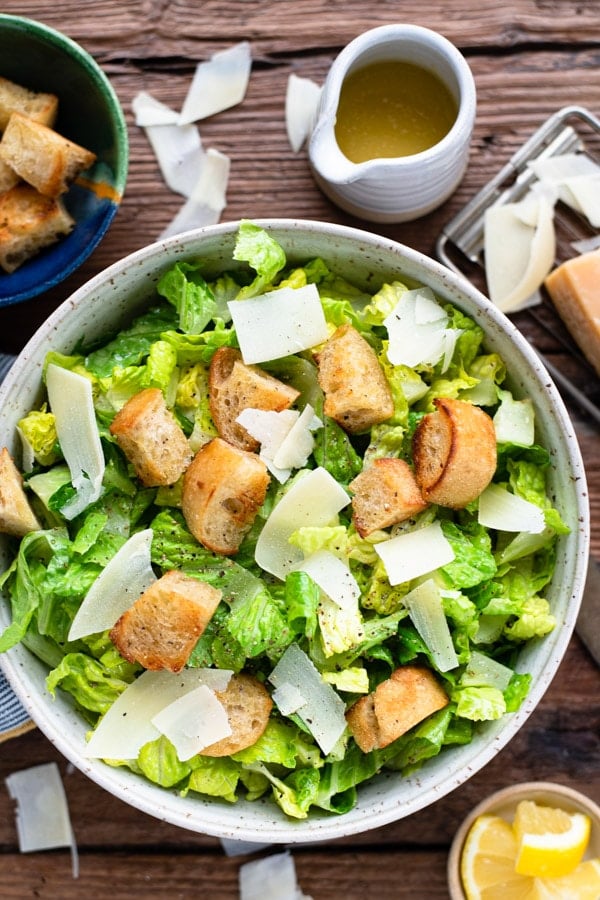 Homemade caesar salad served in a bowl on a wooden table