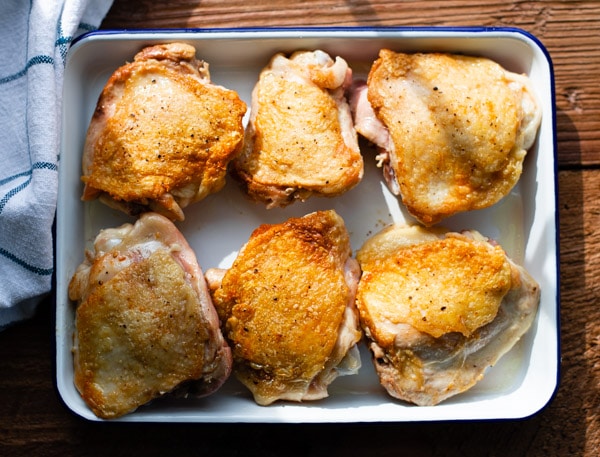 Browned chicken thighs on a platter