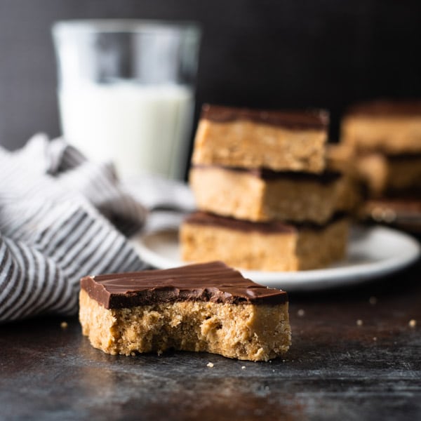 Square shot of no bake chocolate peanut butter bars on a dark surface