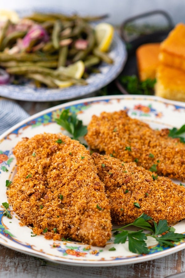 Close up side shot of a platter full of oven baked pecan crusted chicken