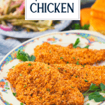 Front shot of pecan crusted chicken breast on a platter with text title overlay