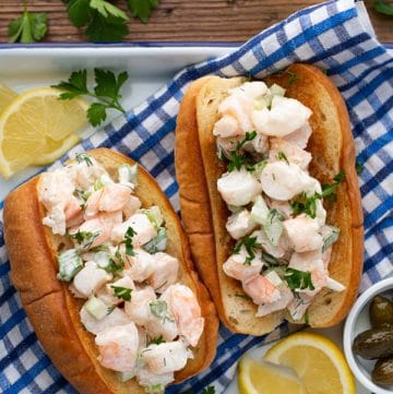 Overhead image of shrimp rolls on a table with a side of lemon and fresh parsley