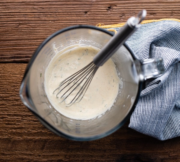 Mayonnaise dressing mixture in a large measuring cup with a whisk