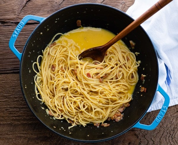 Process shot showing how to make spaghetti carbonara