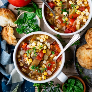 Close square overhead image of two bowls of summer vegetable soup