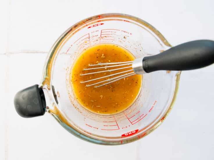 Whisking together a homemade red wine vinaigrette for an antipasto pasta salad recipe.
