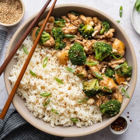 Square overhead shot of a bowl of chicken and broccoli stir fry with rice.