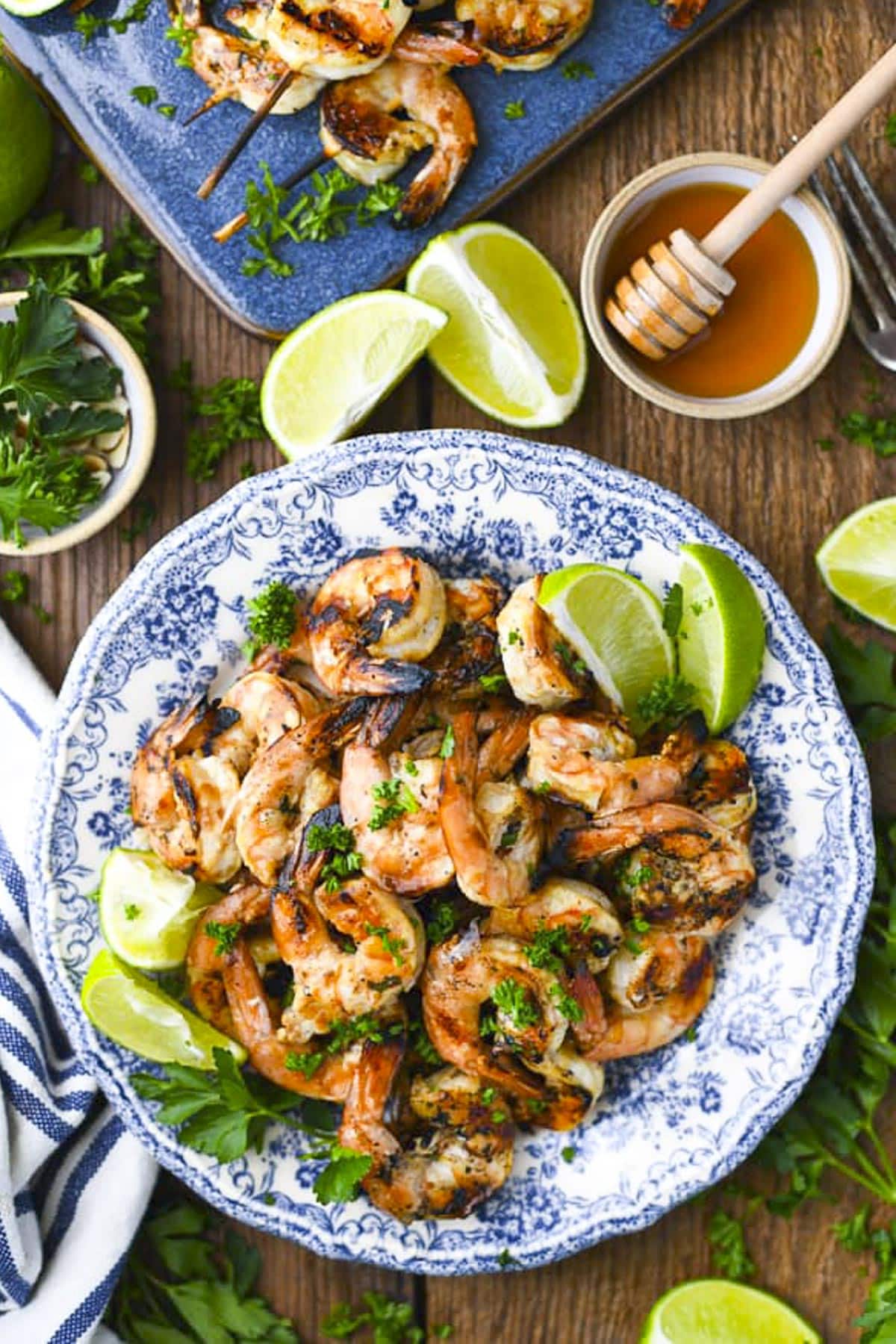 Overhead image of a blue and white plate of the best grilled shrimp marinade used to flavor grilled shrimp.