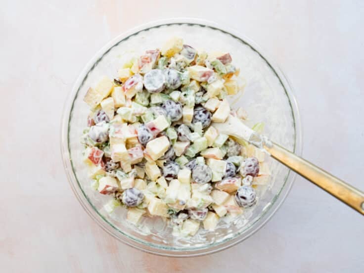 Adding the creamy mayo dressing to the bowl.