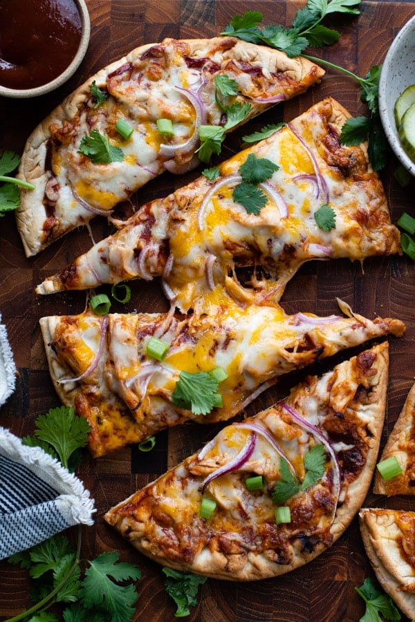 Overhead shot of bbq chicken pizza on a wooden cutting board.
