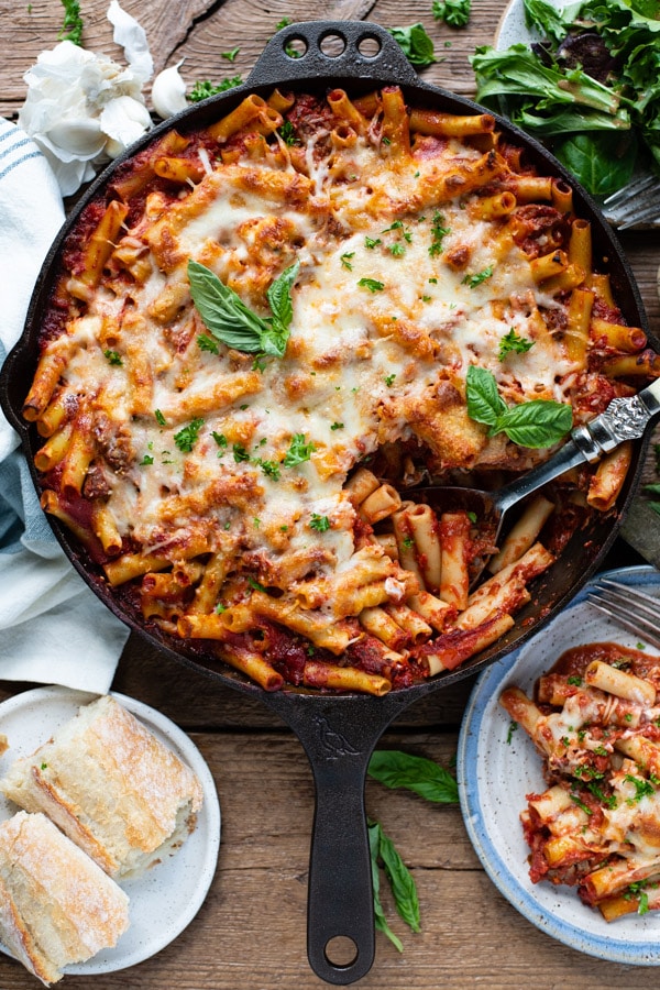 Overhead shot of baked ziti with Italian sausage in a cast iron skillet