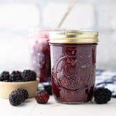 Square side shot of two jars of homemade blackberry jam.