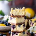 Close up side shot of a stack of blueberry cheesecake bars