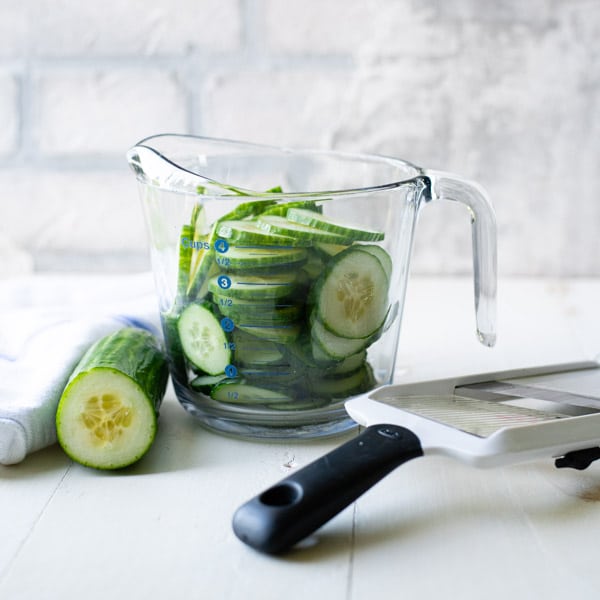 Sliced cucumbers in a measuring cup