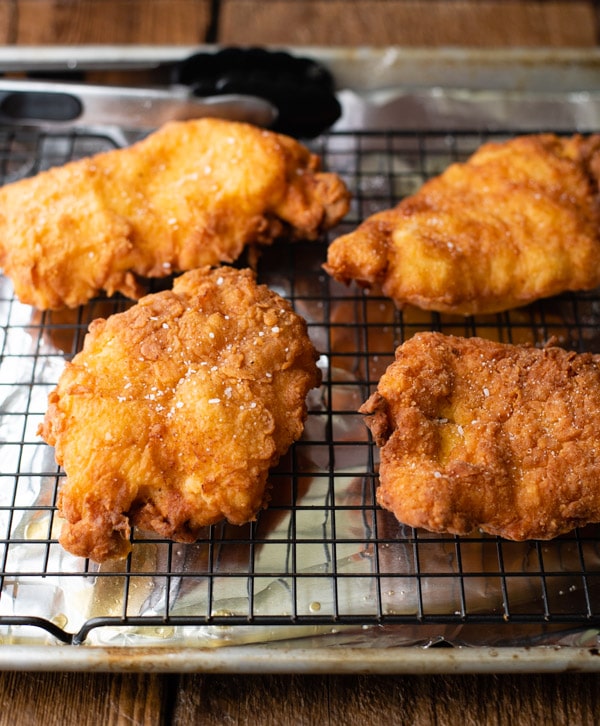 Fried chicken cutlets on a cooling rack