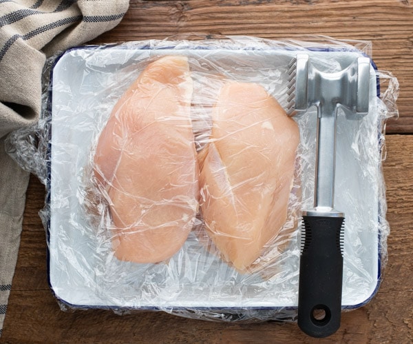 Overhead shot of boneless skinless chicken breast pounded flat with meat mallet
