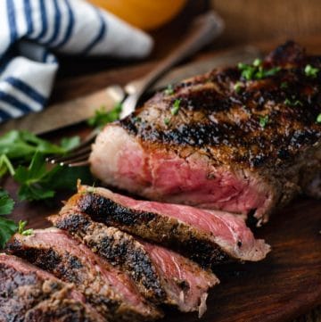 A sliced grilled New York Strip steak on a cutting board