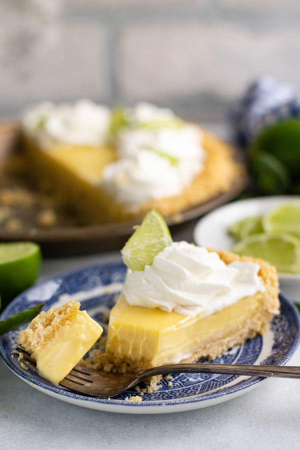 Side shot of a slice of the best key lime pie on a blue and white plate
