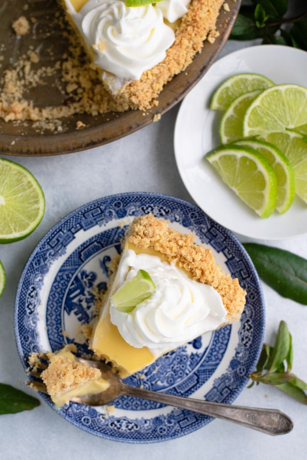 Overhead shot of a slice of traditional key lime pie on a blue and white plate