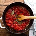 Diced tomatoes in a pot with herbs
