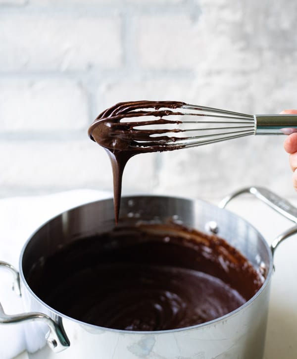 Buttermilk chocolate icing in a pan with a whisk