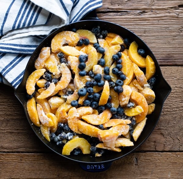 Peaches and blueberries in a cast iron skillet