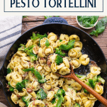 Overhead shot of pesto tortellini in a skillet with text title box at top