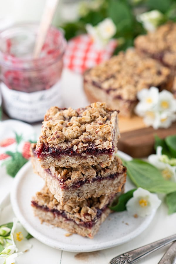 Overhead shot of a stack of raspberry oatmeal bars on a white plate