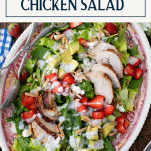Overhead shot of strawberry chicken salad with poppy seed dressing and text title box at top