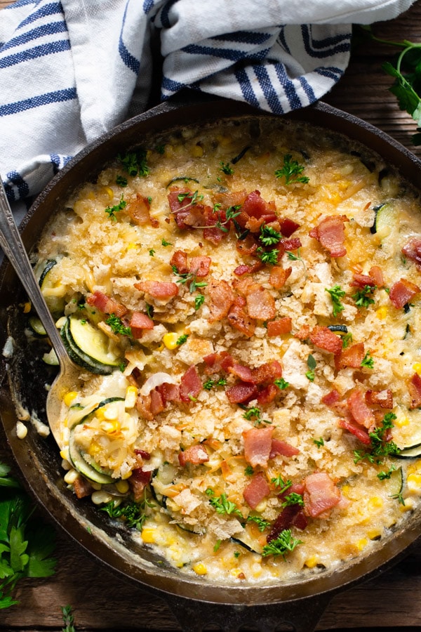 Overhead image of cheesy zucchini gratin with corn and bacon