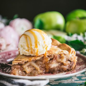 Close up square side shot of a slice of easy apple pie with vanilla ice cream on top