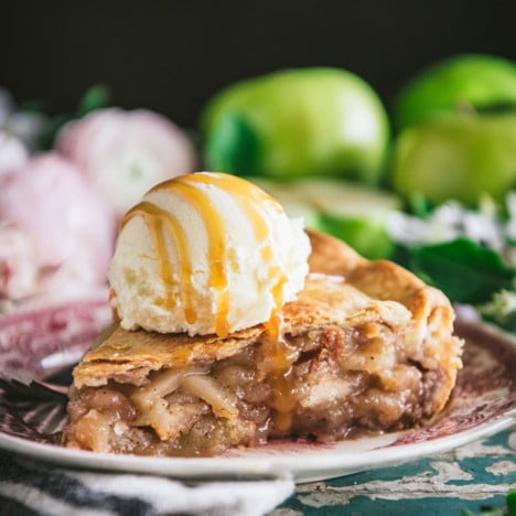 Close up square side shot of a slice of easy apple pie with vanilla ice cream on top