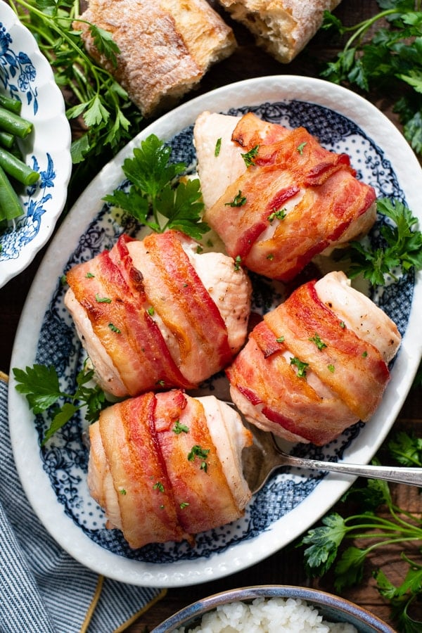 Overhead shot of a plate of bacon wrapped chicken breast on a wooden table