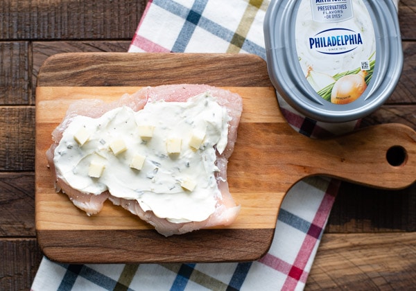 Chicken breast spread with cream cheese and dotted with butter