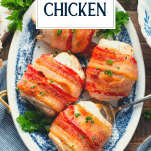 Bacon wrapped chicken with cream cheese on a plate with text title overlay