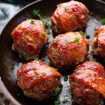 Close up shot of mini bacon wrapped meatloaf in a baking dish