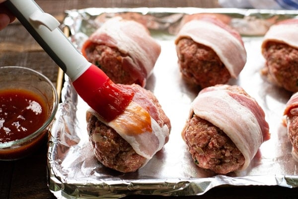 Brushing the top of mini meatloaf with ketchup glaze