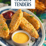 Plate of crispy oven baked chicken tenders with text title overlay