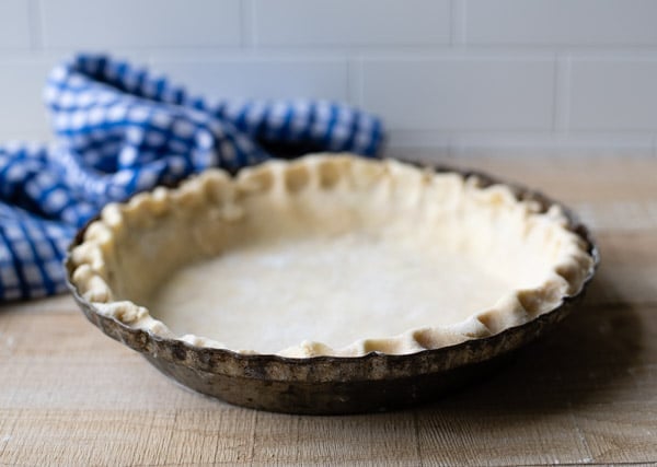 Unbaked homemade pie crust in an old fashioned pie plate