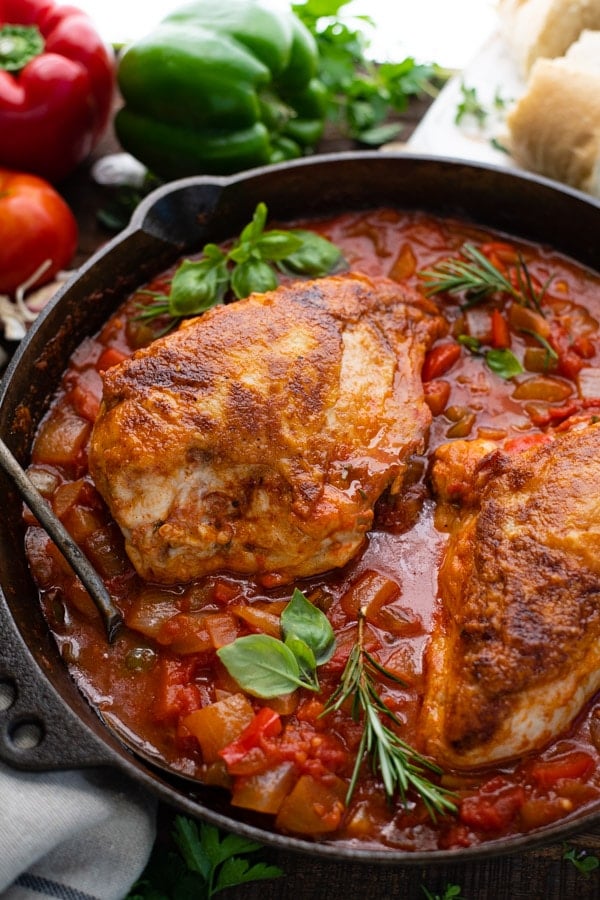 Close up shot of Italian hunters chicken in a skillet with sauce.