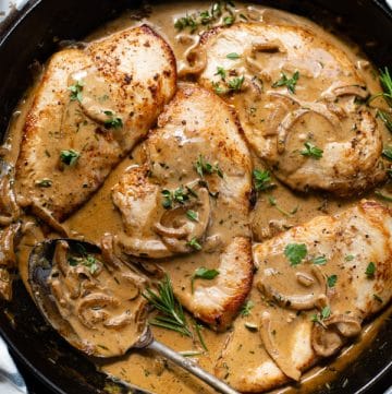 Close overhead image of chicken breast with Dijon mustard sauce in a cast iron skillet