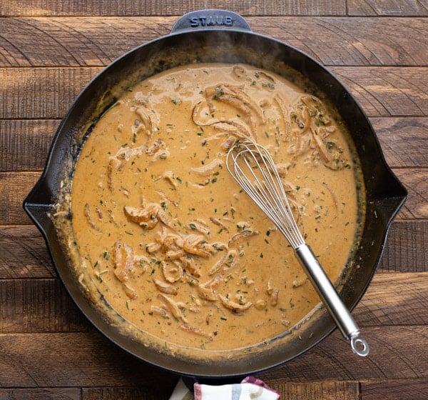 Making chicken Dijon sauce in a skillet with a whisk